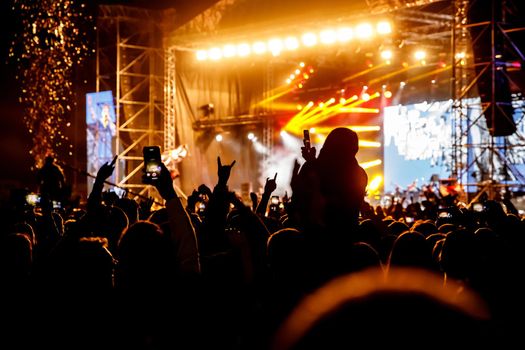 Crowd at a concert. Hands and smartphones in front of the stage