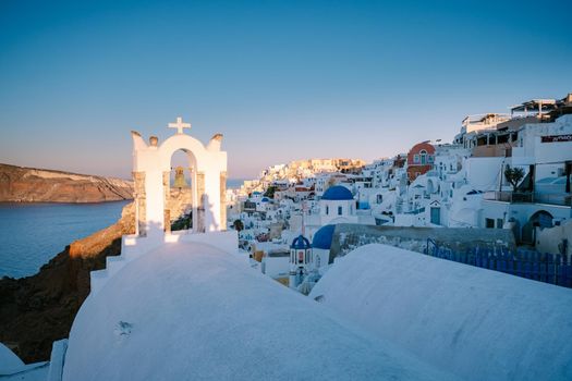 Sunset at the Island Of Santorini Greece, beautiful whitewashed village Oia with church and windmill during sunset, streets of Oia Santorini during summer vacation at the Greek Island