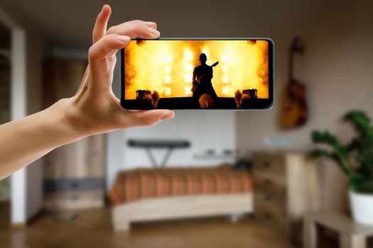 Watching online concert at home by smartphone. Live stream music video