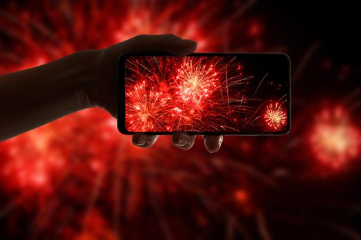 Taking the photo of fireworks via smartphone. Broadcast salute video to the internet