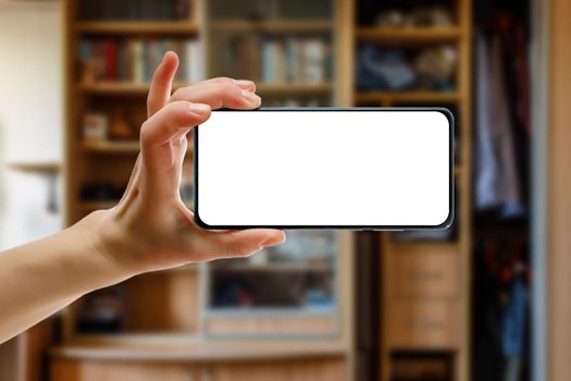 Mockup of using a smartphone in the home interior. Blank white screen for your idea