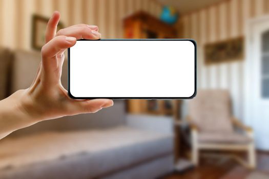 The concept of using a mobile phone at home. Blank white screen for your image.