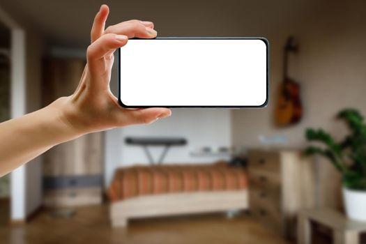 Mockup of using a smartphone in the home interior. Blank white screen for your idea