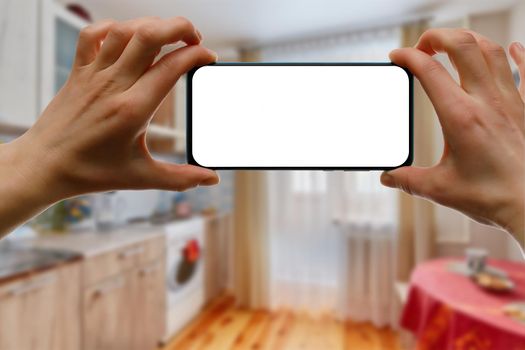 The concept of using a mobile phone at home. Blank white screen for your image.