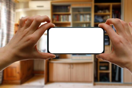 The concept of using a mobile phone at home. Blank white screen for your image.