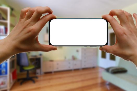 The concept of using a mobile phone at home. Blank white screen for your image.