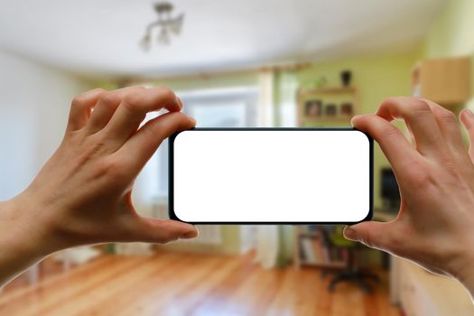 The concept of using a mobile phone at home. Blank white screen for your image.