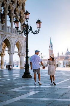 couple on a city trip in Venice, view of piazza San Marco, Doge's Palace Palazzo Ducale in Venice, Italy. Architecture and landmark of Venice. Sunrise cityscape of Venice Italy