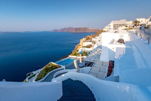 Sunset at the Island Of Santorini Greece, beautiful whitewashed village Oia with church and windmill during sunset, streets of Oia Santorini during summer vacation at the Greek Island