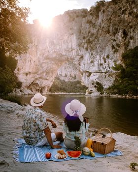 couple on the beach by the river in the Ardeche France Pont d Arc, Ardeche France,view of Narural arch in Vallon Pont D'arc in Ardeche canyon in France Europe
