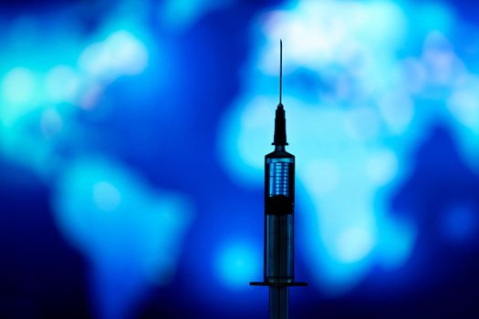Medical syringe for a vaccine. Blue background