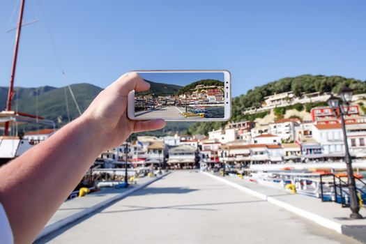 Using your smartphone as a mobile camera while traveling. Tourist city port on screen