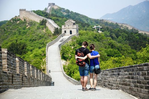 A pair of lovers walk in an embrace on the Great Wall of China