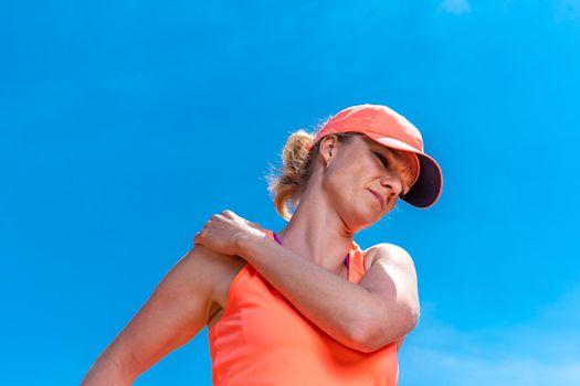 tennis player woman with injury holding the racket on a court.
