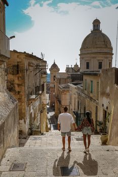 Sicily Italy, view of Noto old town and Noto Cathedral, Sicily, Italy. beautiful and typical streets and stairs in the baroque town of Noto in the province of Syracuse in Sicily, a couple on city trip Noto