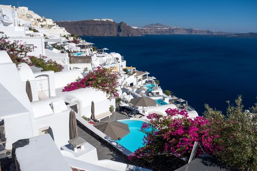 Sunset at the Island Of Santorini Greece, beautiful whitewashed village Oia with church and windmill during sunset, streets of Oia Santorini during summer vacation at the Greek Island