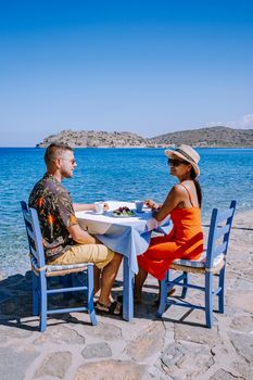 Crete Greece Plaka Lassithi with is traditional blue table and chairs and the beach in Crete Greece. Paralia Plakas, Plaka village Crete, couple on vacation holiday in Greece