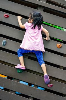 Pretty asian little girls while climbing in a playground