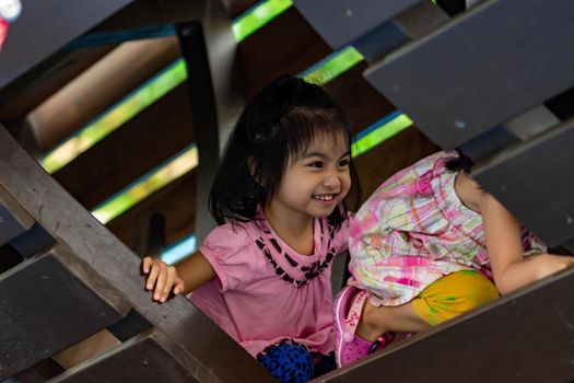 Pretty asian identical twins while enjoying and playing on a playground