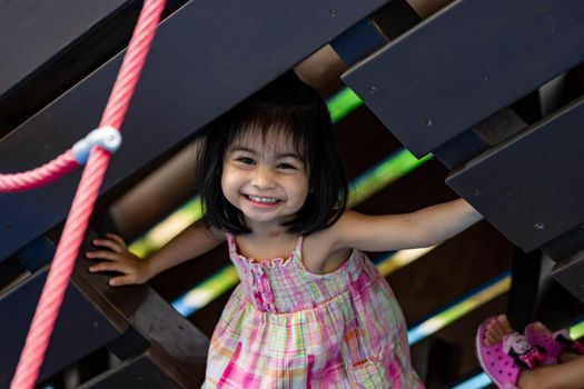 Cute little asian girl while smiling and playing on a playground
