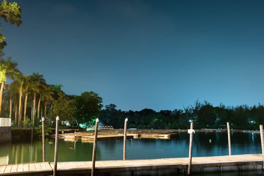 Landscape view of bridge, lake and nature with a bridge. Bright night sky with stars and smooth light reflecting on waters somewhere in Asia