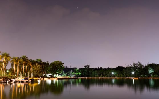 Horizontal view of lake and nature during dusk with night stars and smooth reflection on waters somewhere in Asia