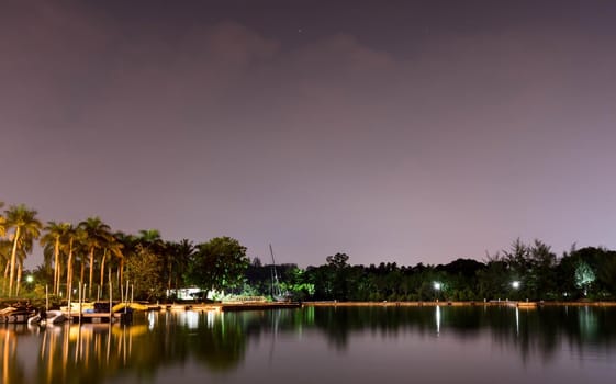 Horizontal view of lake and nature during dusk with night stars and smooth reflection on waters somewhere in Asia