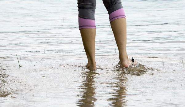 Female feet while walking in a beach waters