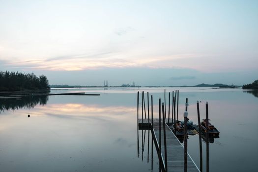 Beach landscape view with wooden foot bridge during sunset. Beatiful screnery of a beach with ocean and sky and water reflections