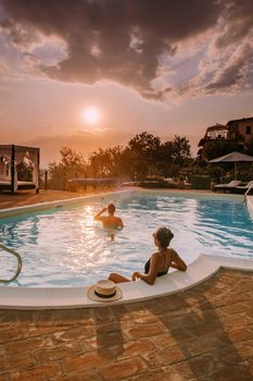 Luxury country house with swimming pool in Italy. Pool and old farm house during sunset central Italy. Couple on Vacation at luxury villa in Italy, men and woman watching sunset