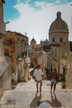 Sicily Italy, view of Noto old town and Noto Cathedral, Sicily, Italy. beautiful and typical streets and stairs in the baroque town of Noto in the province of Syracuse in Sicily, a couple on city trip Noto