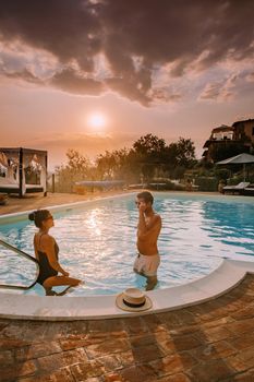 Luxury country house with swimming pool in Italy. Pool and old farm house during sunset central Italy. Couple on Vacation at luxury villa in Italy, men and woman watching sunset