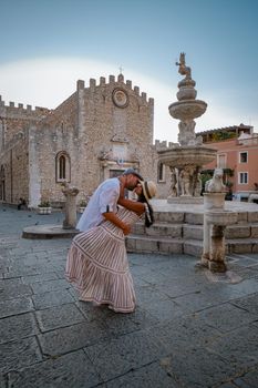 Taormina Sicily, Belvedere of Taormina and San Giuseppe church on the square Piazza IX Aprile in Taormina. Sicily, Italy. Couple on vacation at the Italian Island Sicily