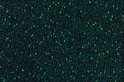 black melange manually knitted fabric with emerald green and blue blotches - seamless texture and flat background.