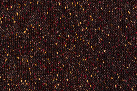 black melange manually knitted fabric with red and yellow blotches - seamless texture and flat background.
