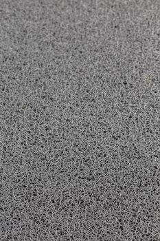 abstract gray background of rubber hair synthetic welcome mat with selective focus and blur.
