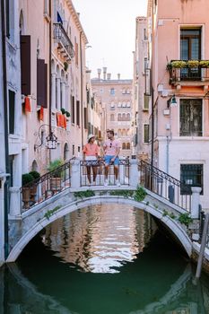 couple men and woman on a city trip to Venice Italy, colorful streets with canals Venice. Europe