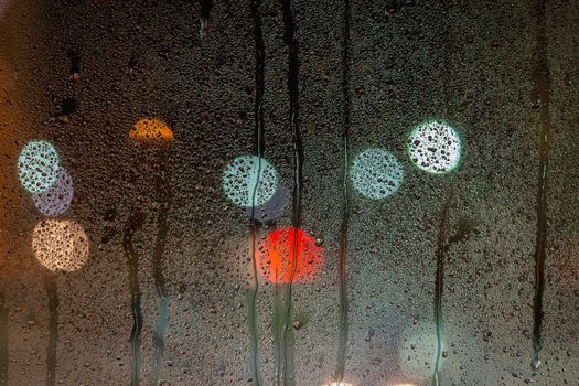 an abstract background of night wet window glass with smudges.