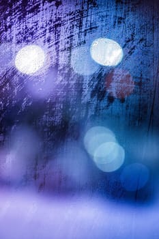 an abstract background of night wet window glass with smudges in blue tone gamma.
