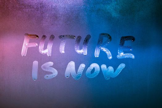 words future is now handwritten on night wetwindow glass surface, close-up with selective focus
