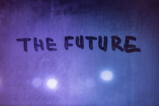 word the future handwritten on night wet window glass surface, close-up with selective focus