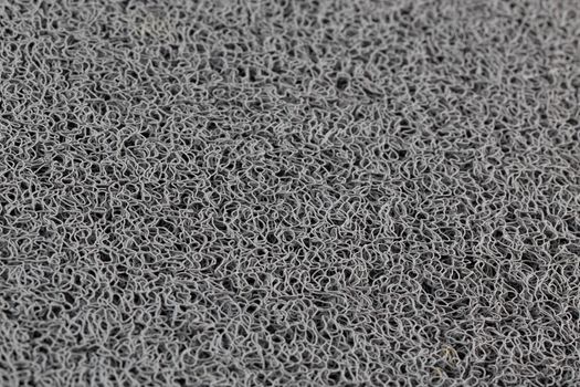 abstract gray background of rubber hair synthetic welcome mat with selective focus and blur.