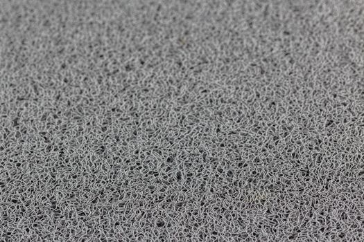 abstract gray background of rubber hair synthetic welcome mat with selective focus and blur.