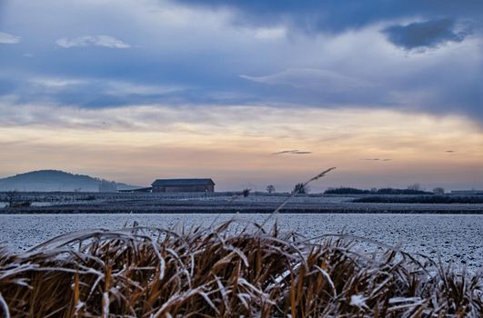Winter landscape with building and clouds