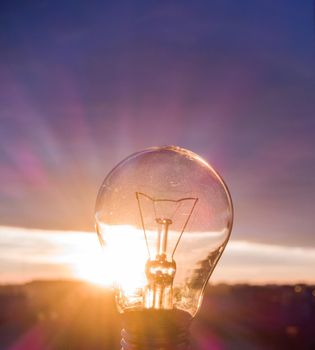 A lamp in the sun. Pure light energy. A beautiful sunset through an incandescent lamp.