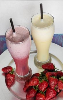 Fruit milky cocktails with strawberry on a white pot