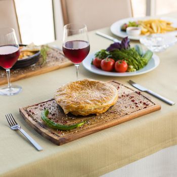 Tasty meat meal with bread, red wine glass, vegetables