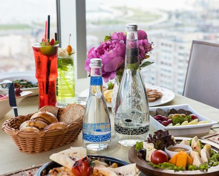 Tasty meals on the restaurant table, cocktail, water bread