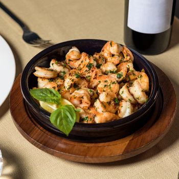 Scampi shrimp meal in the black pot plate close up