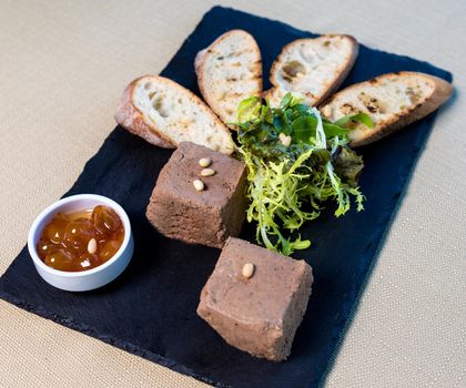 Jam with bread tapas and herbs on the black plate